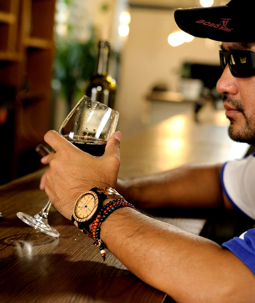 man drinking wine wearing watch