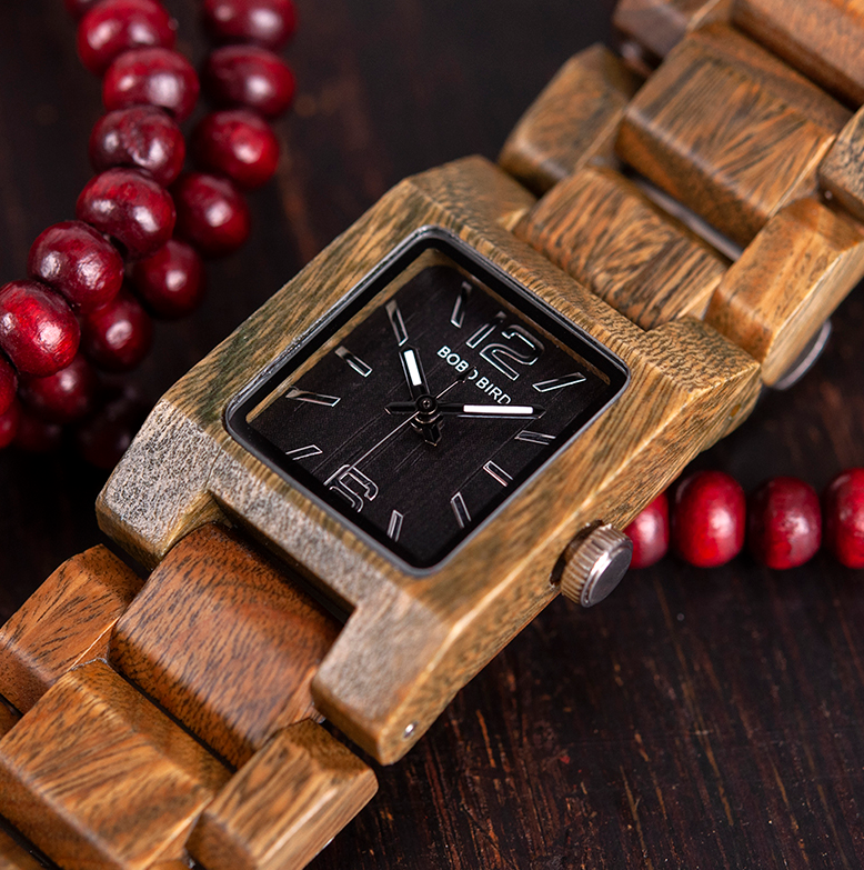 quartz wood watch laying on red beads