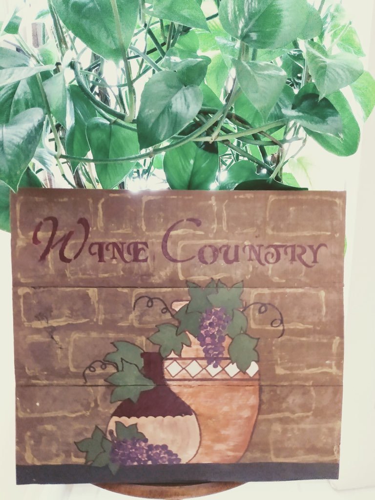 wine country wood sign in front of plant